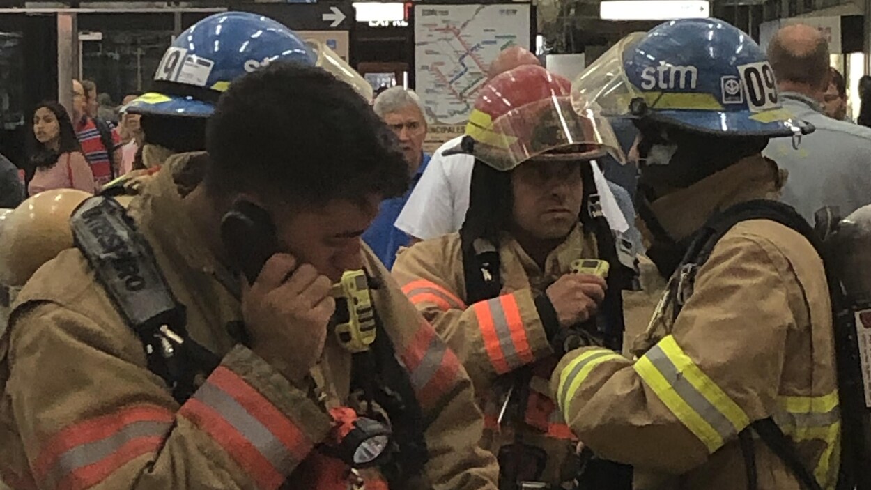 Des intervenants portant des uniformes et des casques discutent.