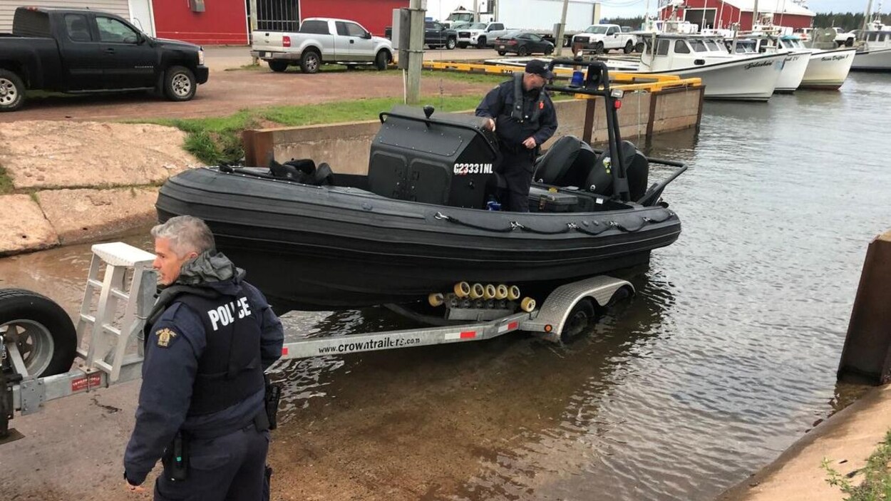 Deux agents de la GRC mette un bateau de recherche à l'eau.