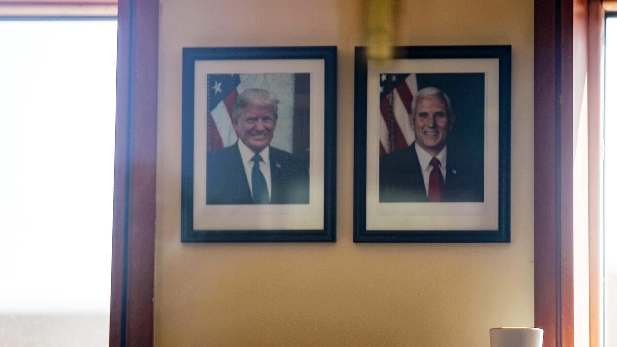 Des photographies du président américain Donald Trump et du vice-président Mike Pence sont accrochées à un mur à l'intérieur du bureau de la sécurité à l'entrée du bâtiment de l'ambassade américaine, à Bagdad.