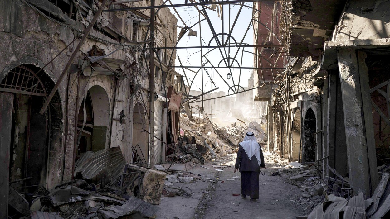 Un homme marche au milieu d'un paysage de désolation à Mossoul. Un homme marche au milieu d'un paysage de désolation à Mossoul.