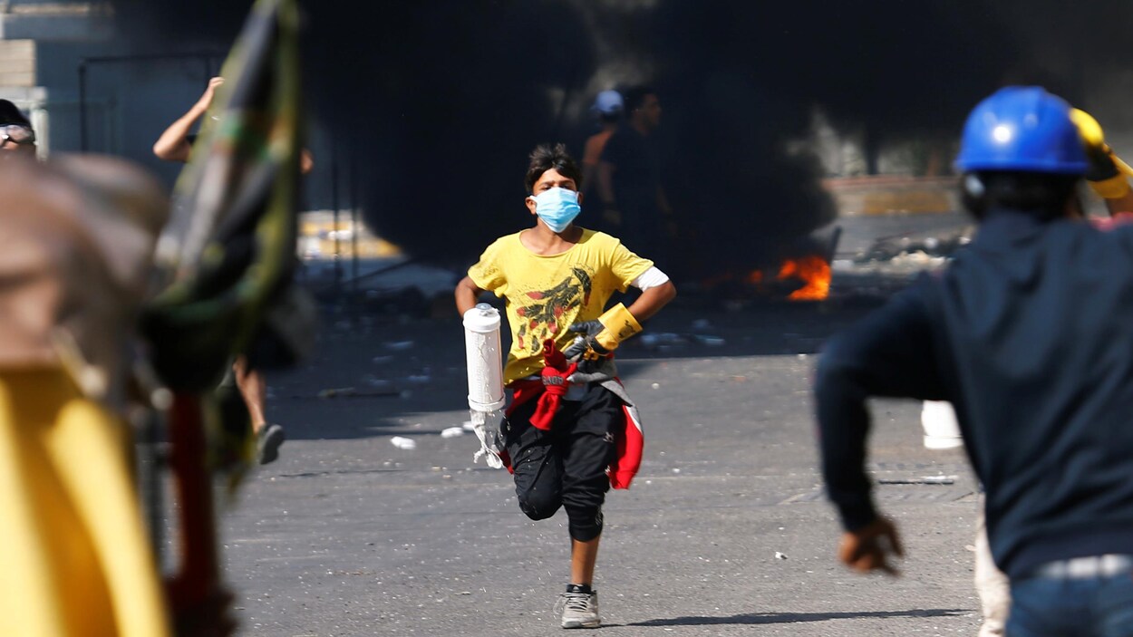 Un jeune homme court lors d'une manifestation