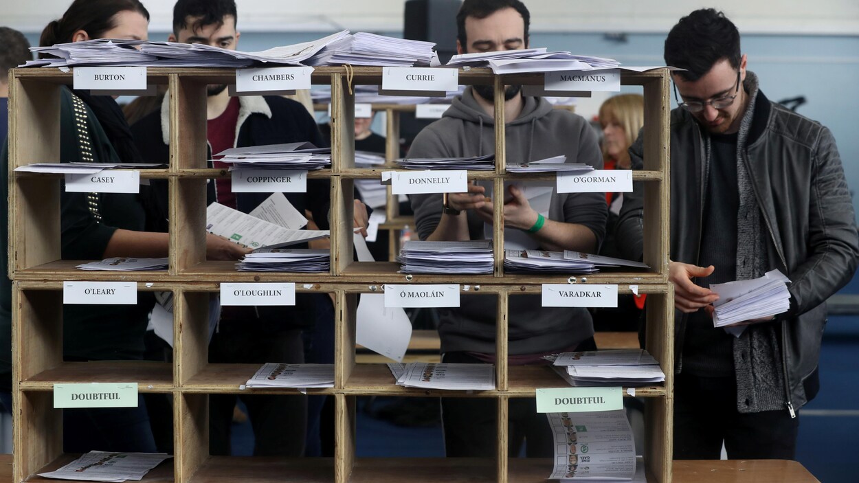 Des personnes trient les listes de candidats aux élections.