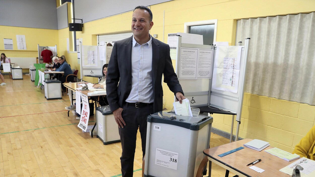 Un politicien irlandais dépose un bulletin de vote dans une urne.