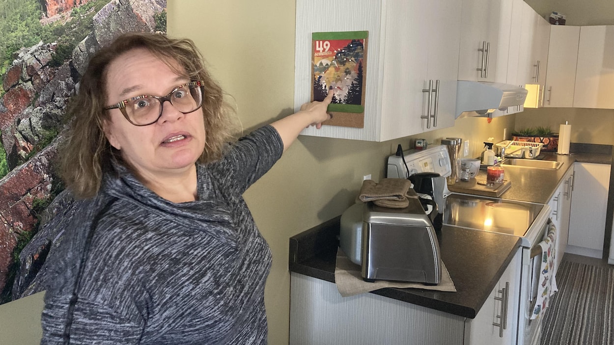 Isabelle Desbiens pointe une carte des sommets du Québec affichée dans sa cuisine.