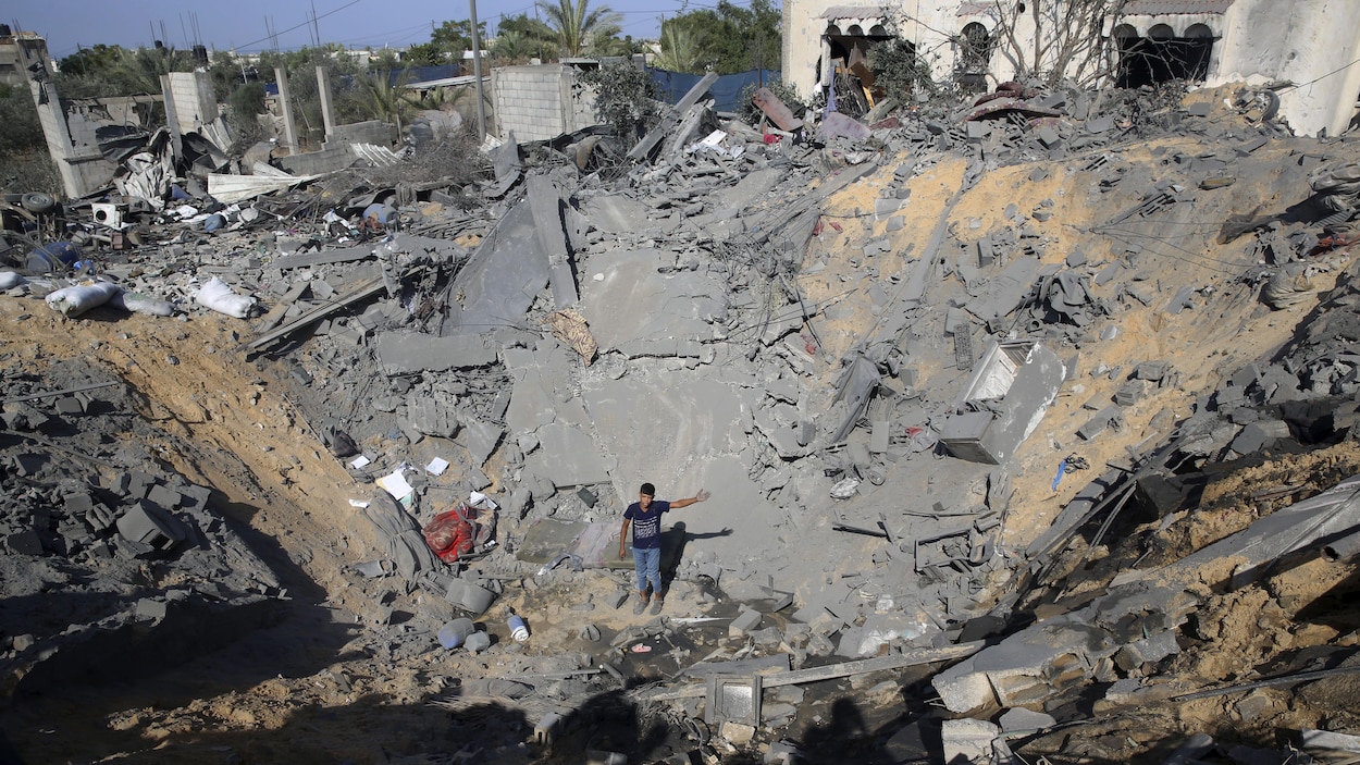 Un jeune Palestinien, dans le cratère fait par un missile israélien, où se trouvait une maison à Al-Qarara, dans la bande de Gaza.