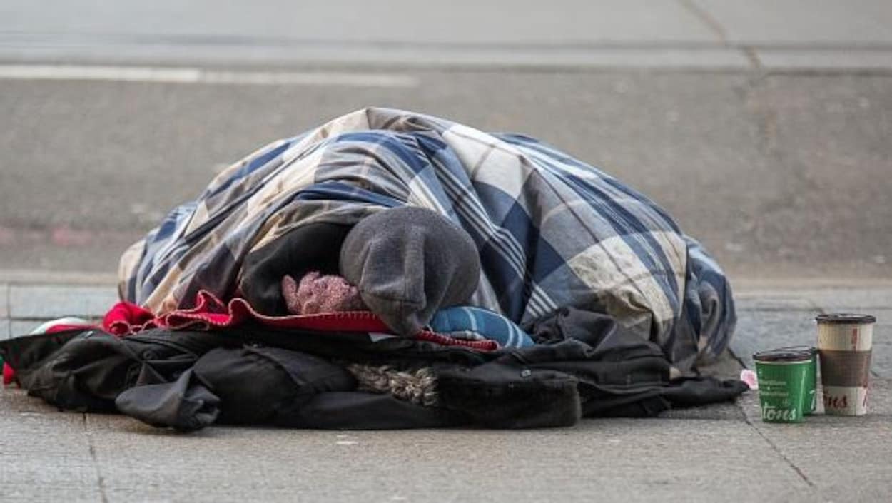 un homme qui dort dans la rue.