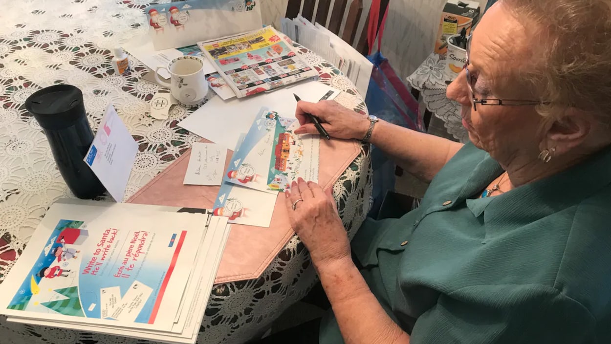 Izzy McQueen qui rédige une lettre sur un papier aux couleurs de Noël.