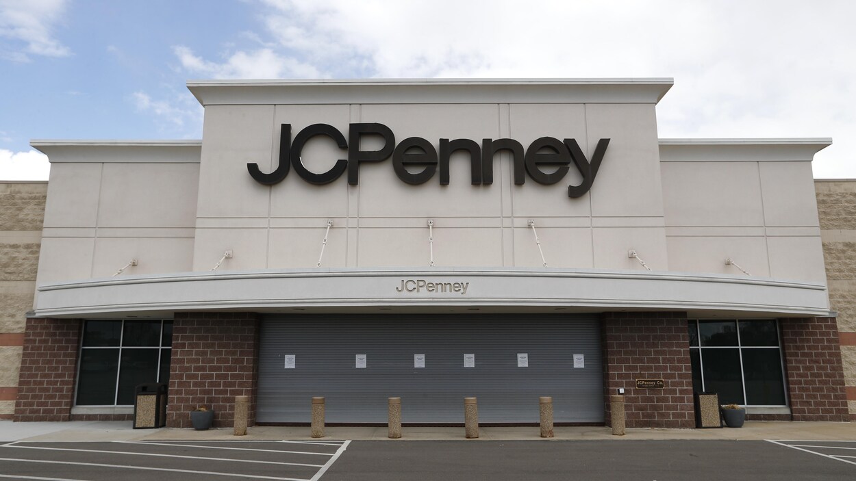 Un magasin J. C. Penney dont l'entrée est fermée par un rideau métallique et dont le stationnement extérieur est désert.