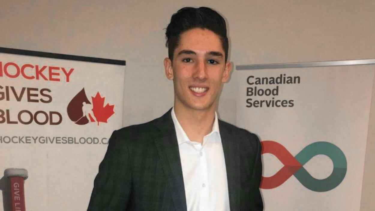 Jacob Ingham, souriant, tient son prix à la main.
