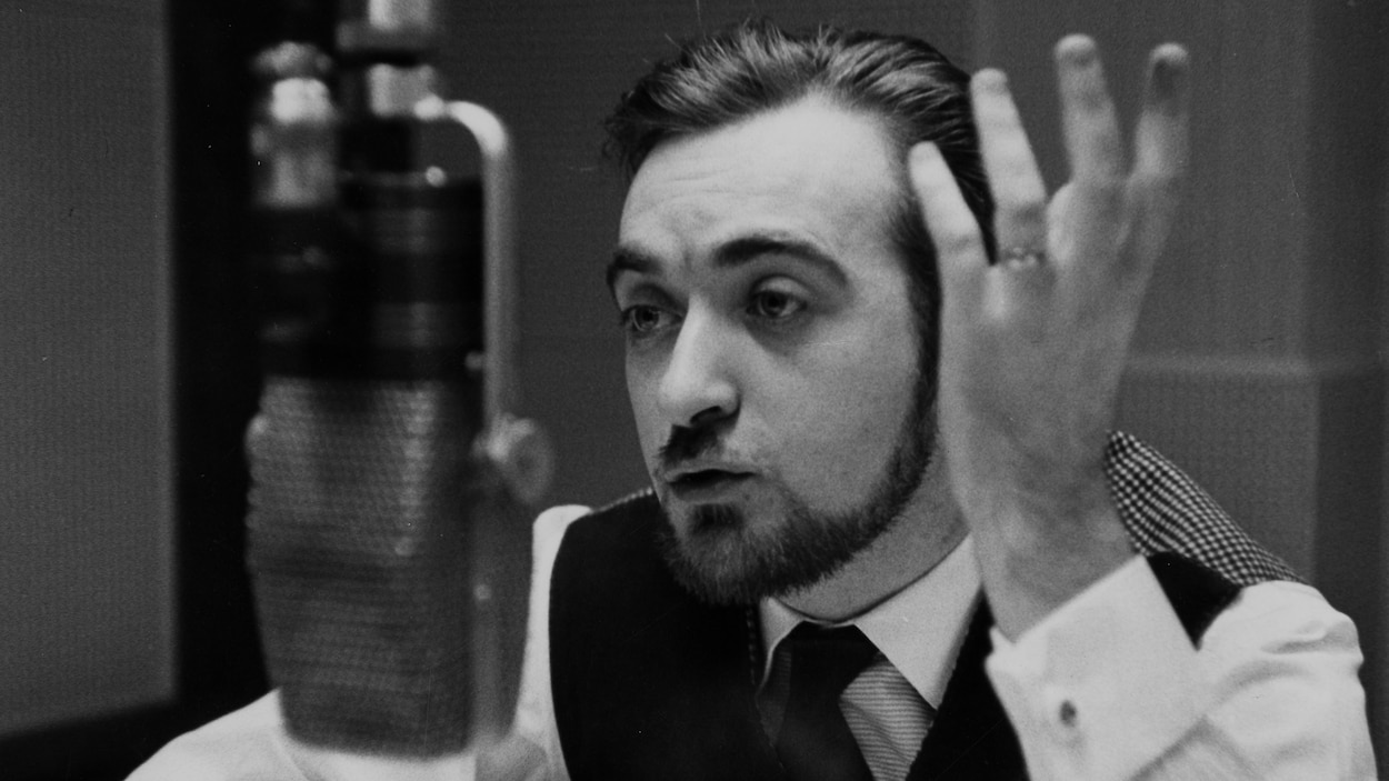 L'animateur parle et gesticule, derrière le micro, dans un studio de radio. L'animateur parle et gesticule, derrière le micro, dans un studio de radio.