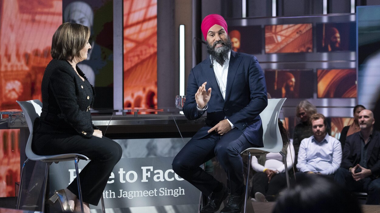 Jagmeet Singh, sur le plateau de The National, avec Rosemary Barton. Des membres du public sont visibles en arrière-plan.
