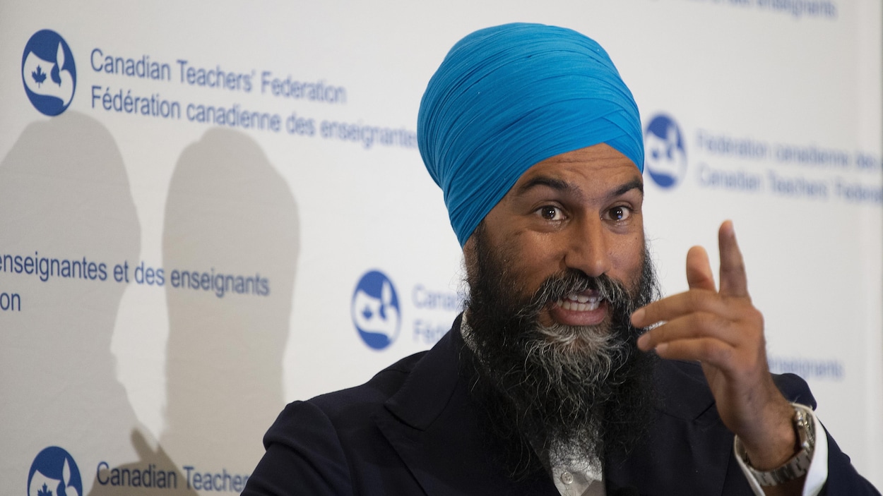 Un homme à la barbe longue portant le turban a le doigt levé.