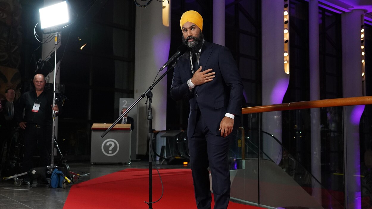 Jagmeet Singh porte la main à sa poitrine devant un micro.