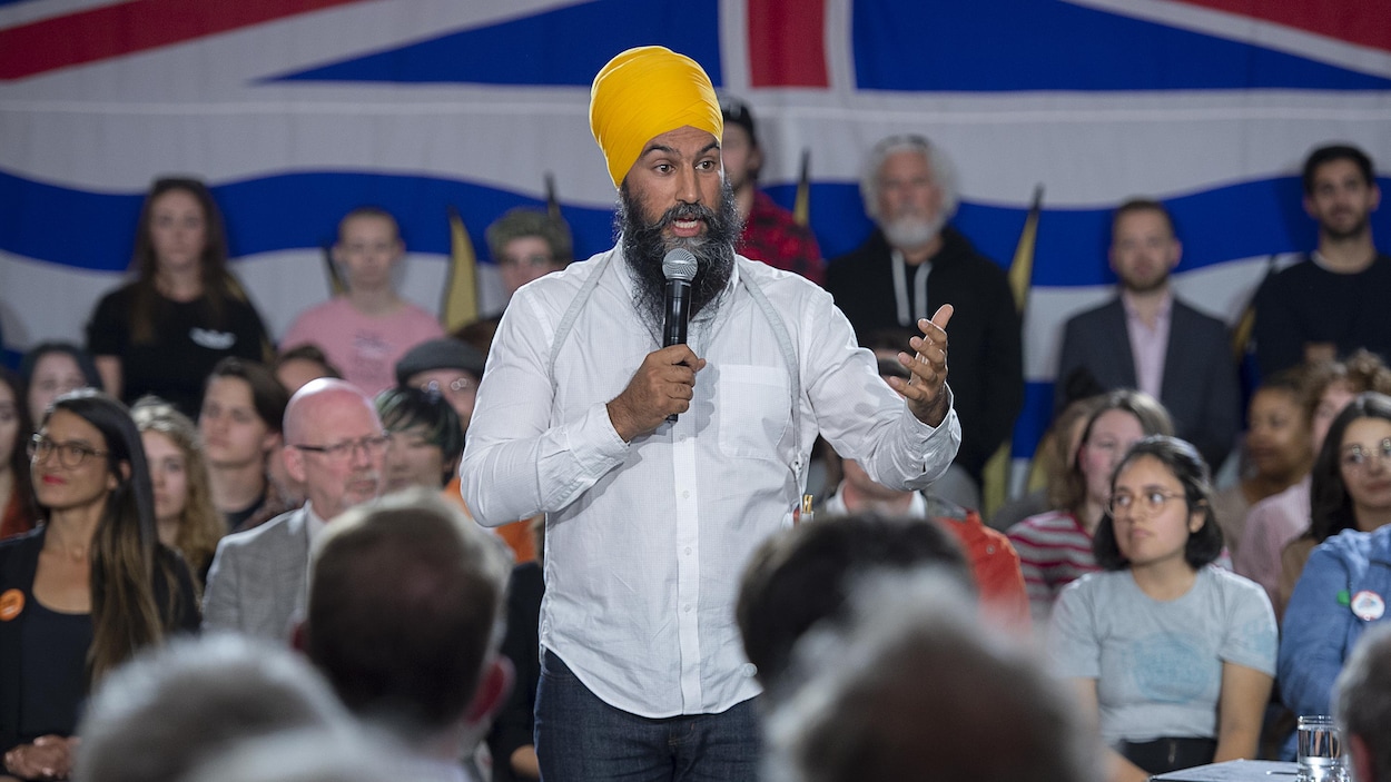 Jagmeet Singh est au beau milieu d'une foule et s'adresse au micro lors d'un rassemblement.