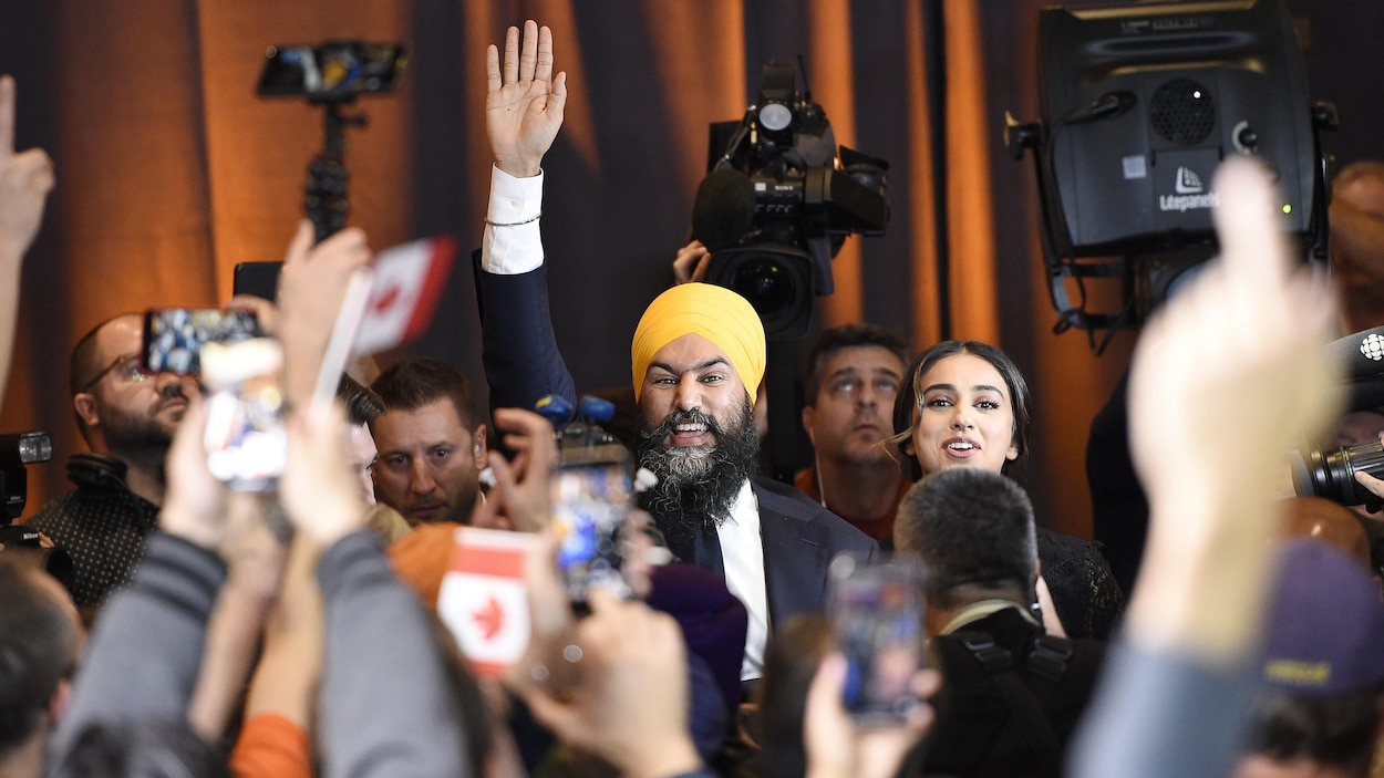 Jagmeet Singh salue la foule à son arrivée avec sa femme.