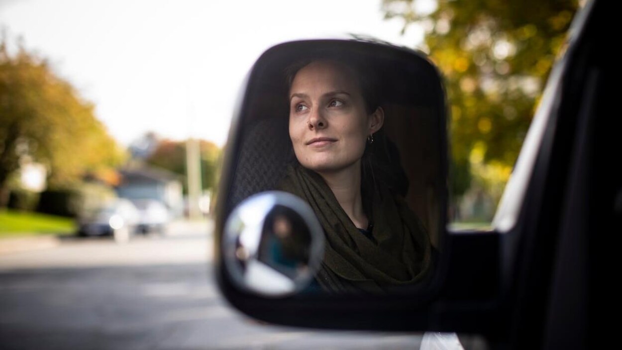 Un rétroviseur reflète l'image de Jaklyn De Vos.