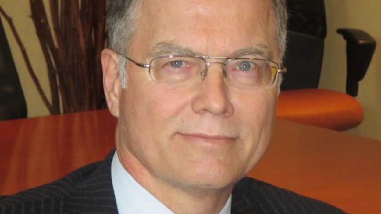 James Duggan est assis dans un bureau.