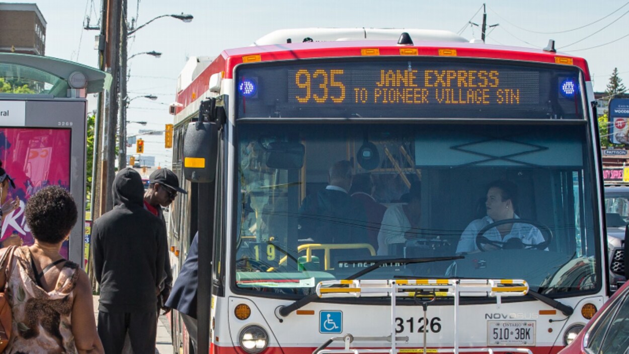 Des usagers montent à bord d'un autobus.