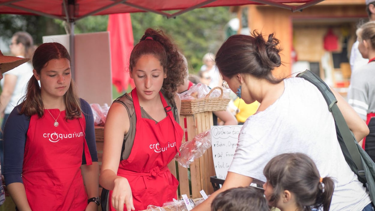 Deux jeunes qui vendent leurs produits dans un marché public.