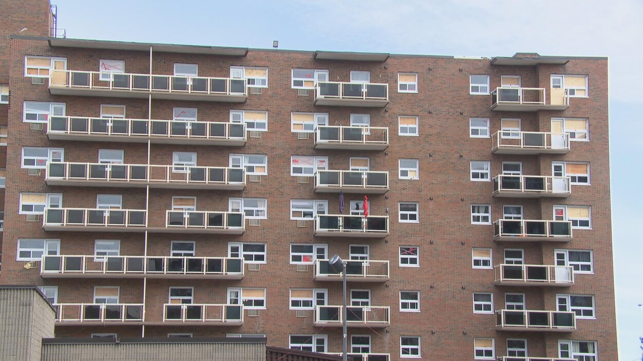 Un immeuble à logements qui comptent plusieurs fenêtres placardées.