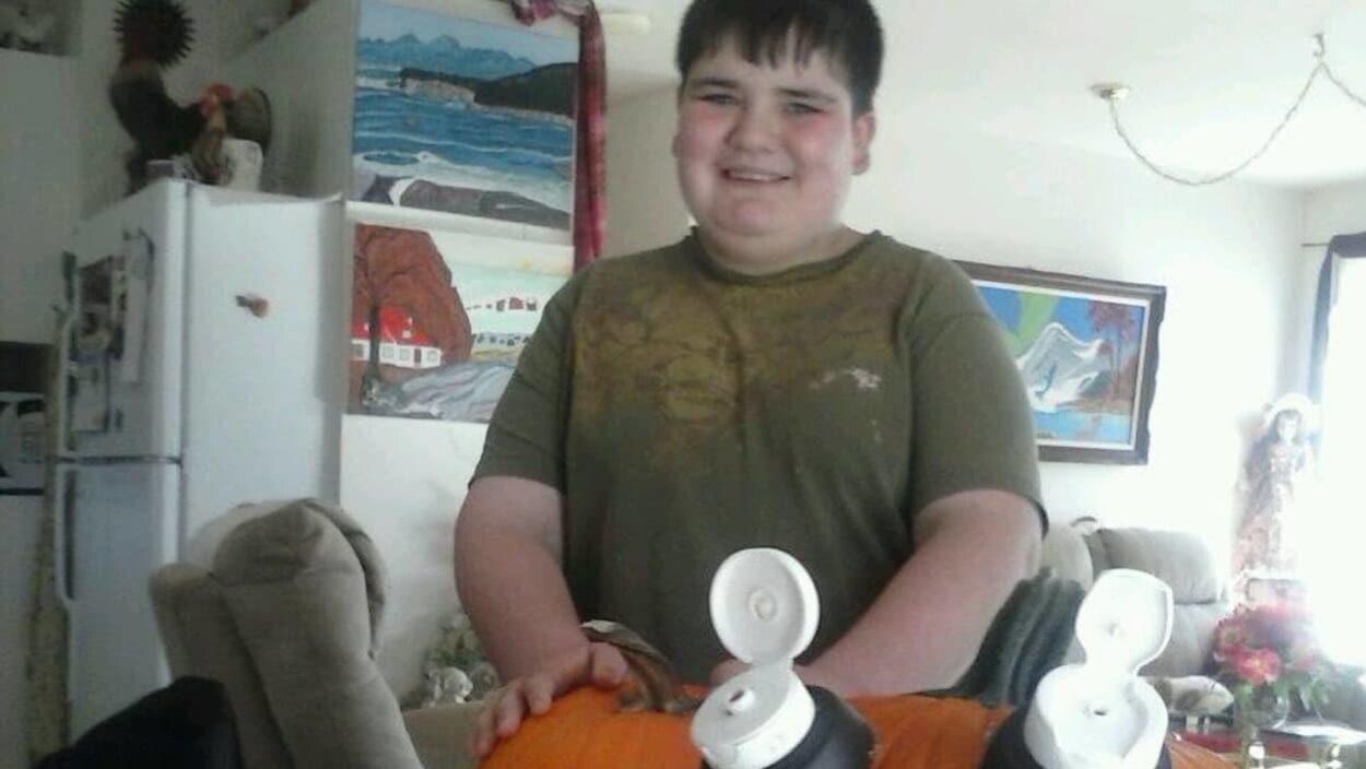 L'adolescent pose, souriant, dans un appartement L'adolescent pose, souriant, dans un appartement