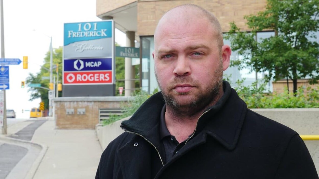 Photo d'un homme debout à l'extérieur devant une enseigne de Rogers.