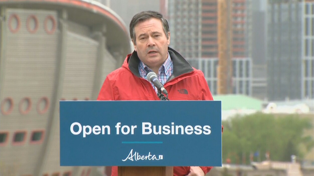 Jason Kenney en conférence de presse, à Calgary, devant le Saddledome.
