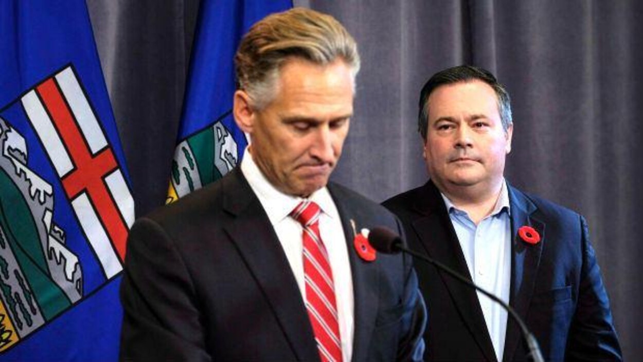 Le chef du Parti conservateur uni, Jason Kenney, à droite, regarde Dave Rodney annoncer sa démission du poste de député de Calgary-Lougheed.