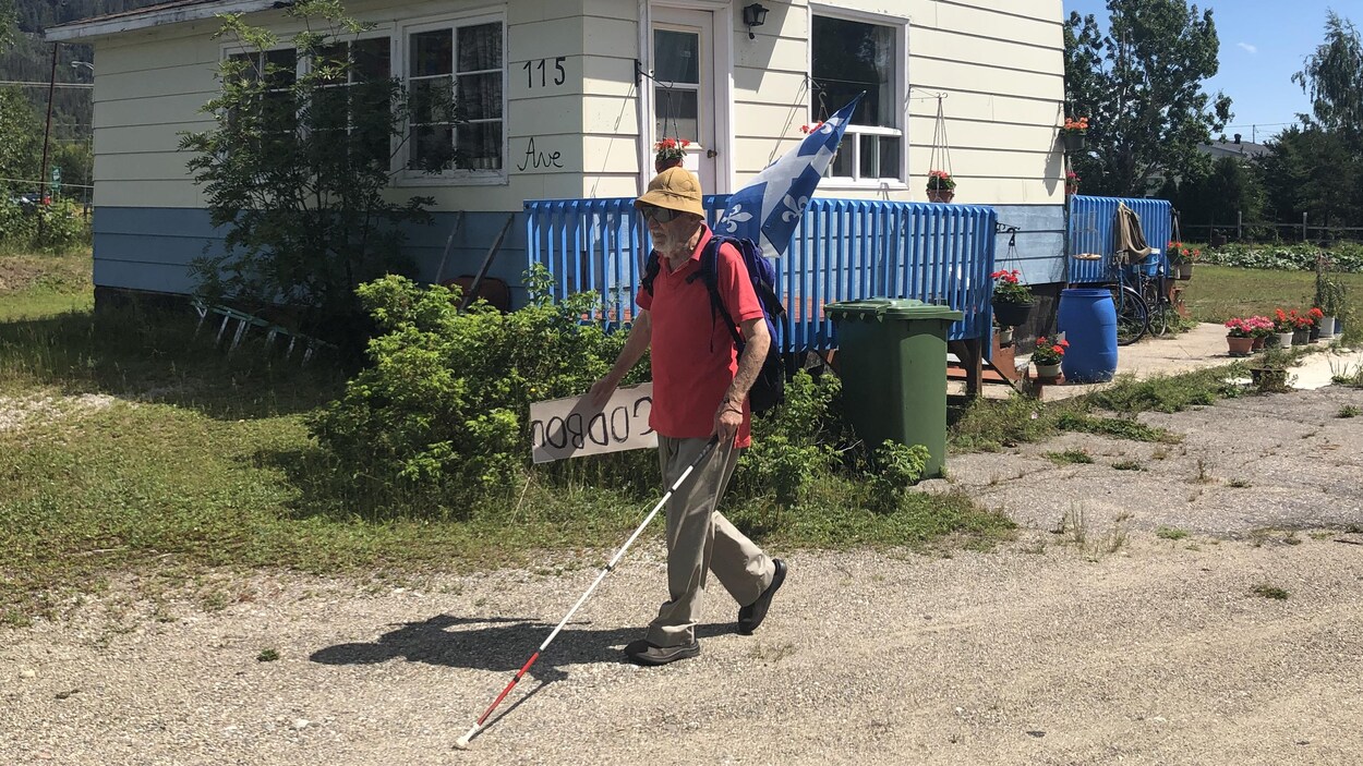 Un homme âgé marche à l'extérieur avec une canne pour non-voyant.