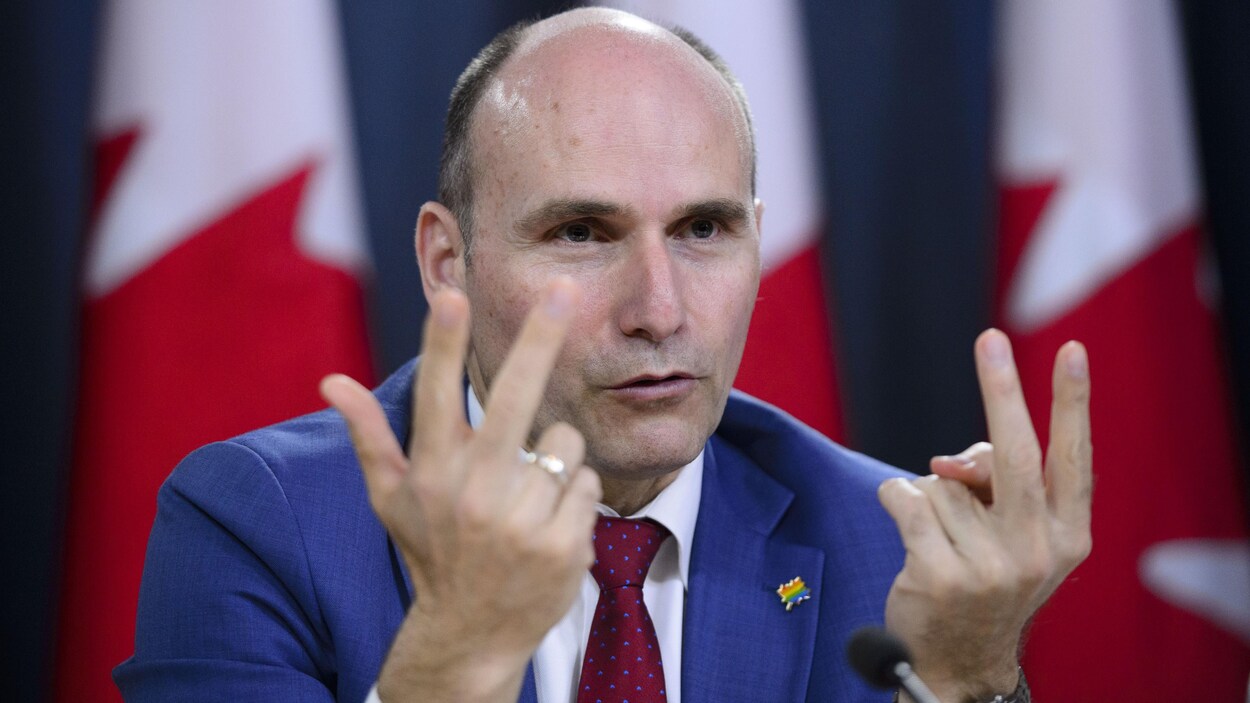 Le ministre du Développement social, Jean-Yves Duclos, parle aux médias assis à la tribune de la presse à Ottawa.