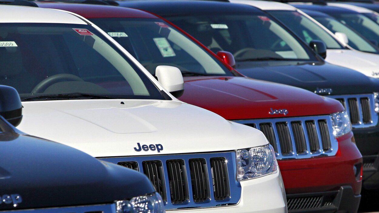 Plusieurs VUS de marque Jeep Grand Cherokee alignés chez un concessionnaire.