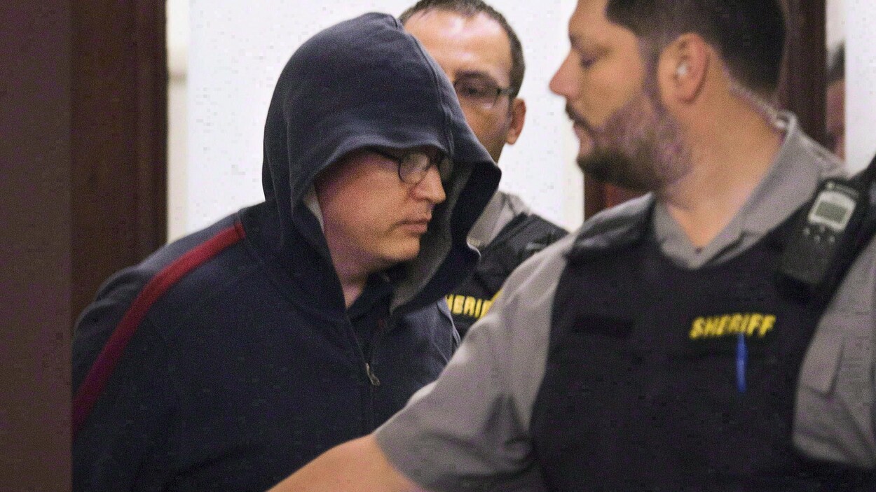 Jeffrey Paul Delisle escorté par des policiers au tribunal.