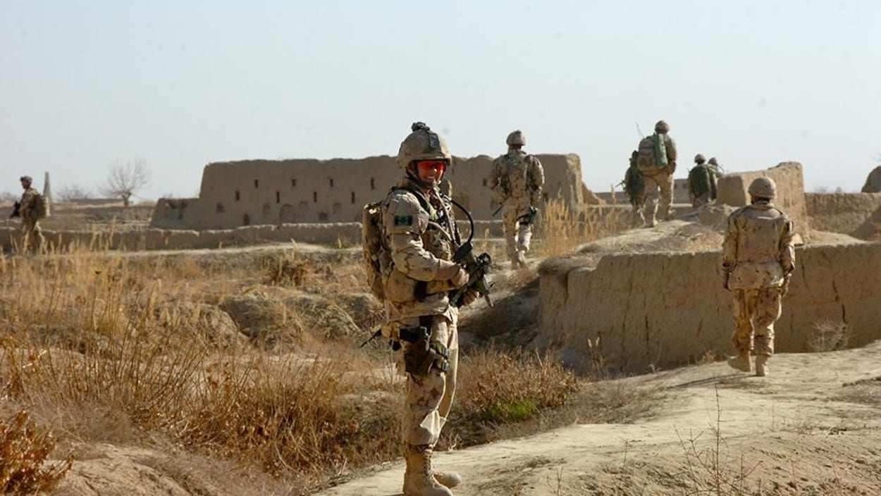 Jennie Carignan en uniforme militaire dans une zone désertique, en Afghanistan.