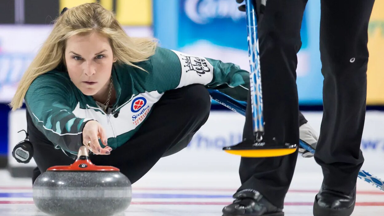 Jennifer Jones est sur la glace et vient de lancer une pierre de curling.