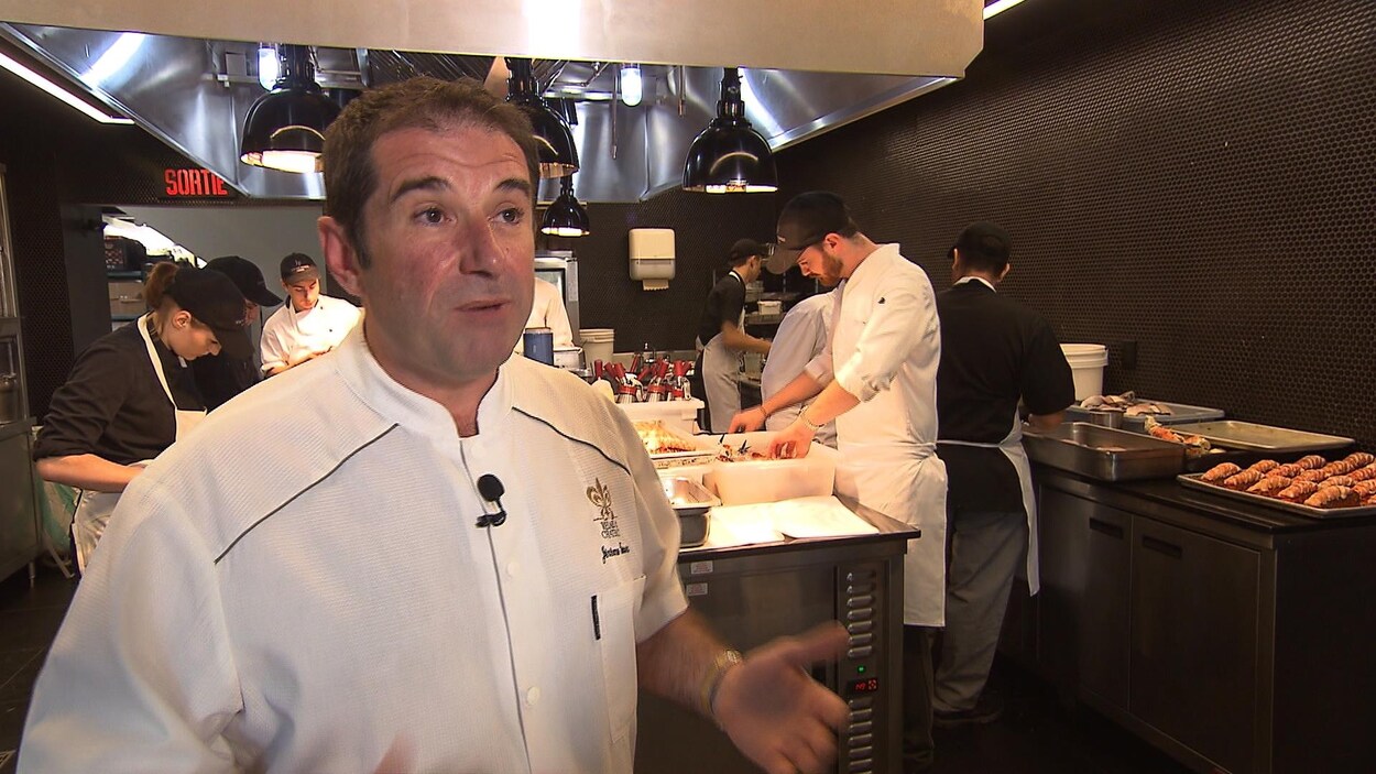 Un homme avec des cuisiniers en arrière plan