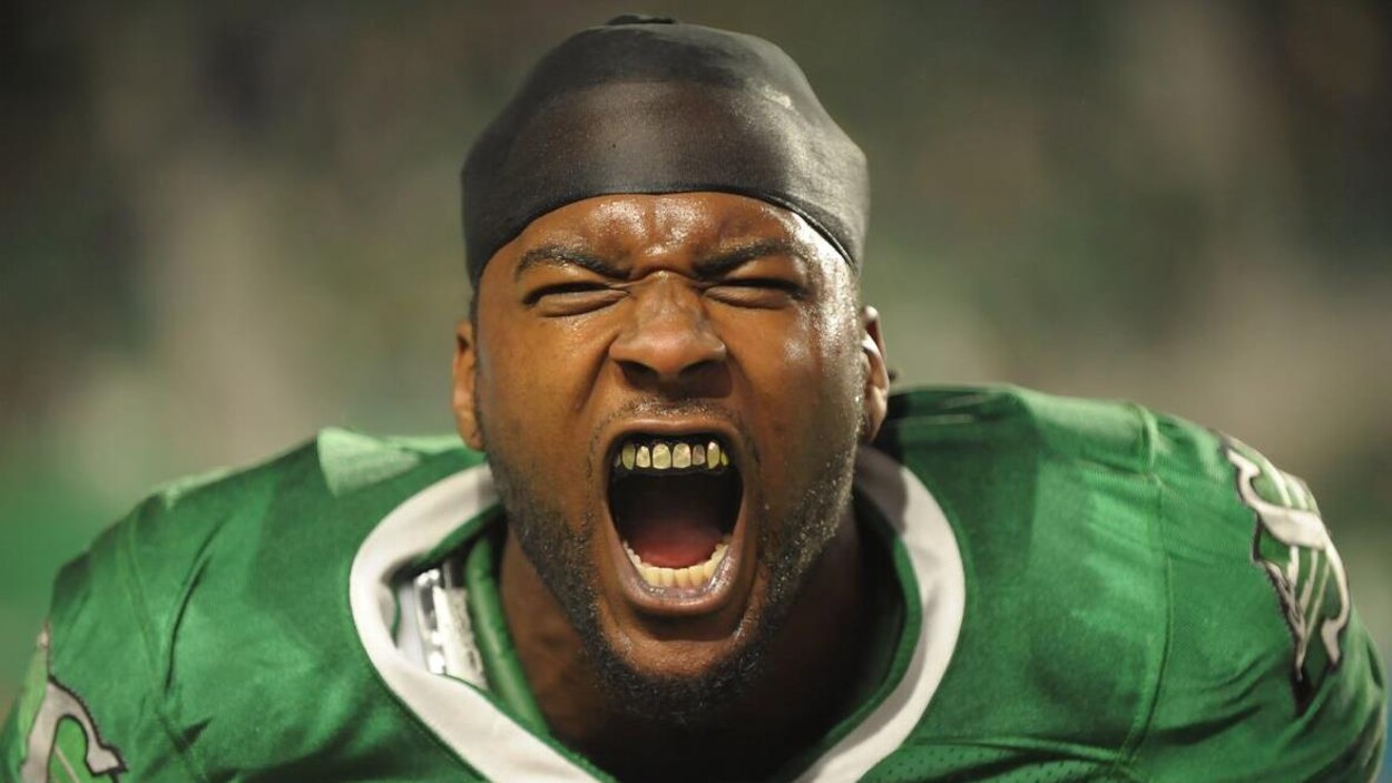 Jerome Messam ouvre la bouche en rugissant, vêtu de son uniforme de football. Jerome Messam ouvre la bouche en rugissant, vêtu de son uniforme de football.