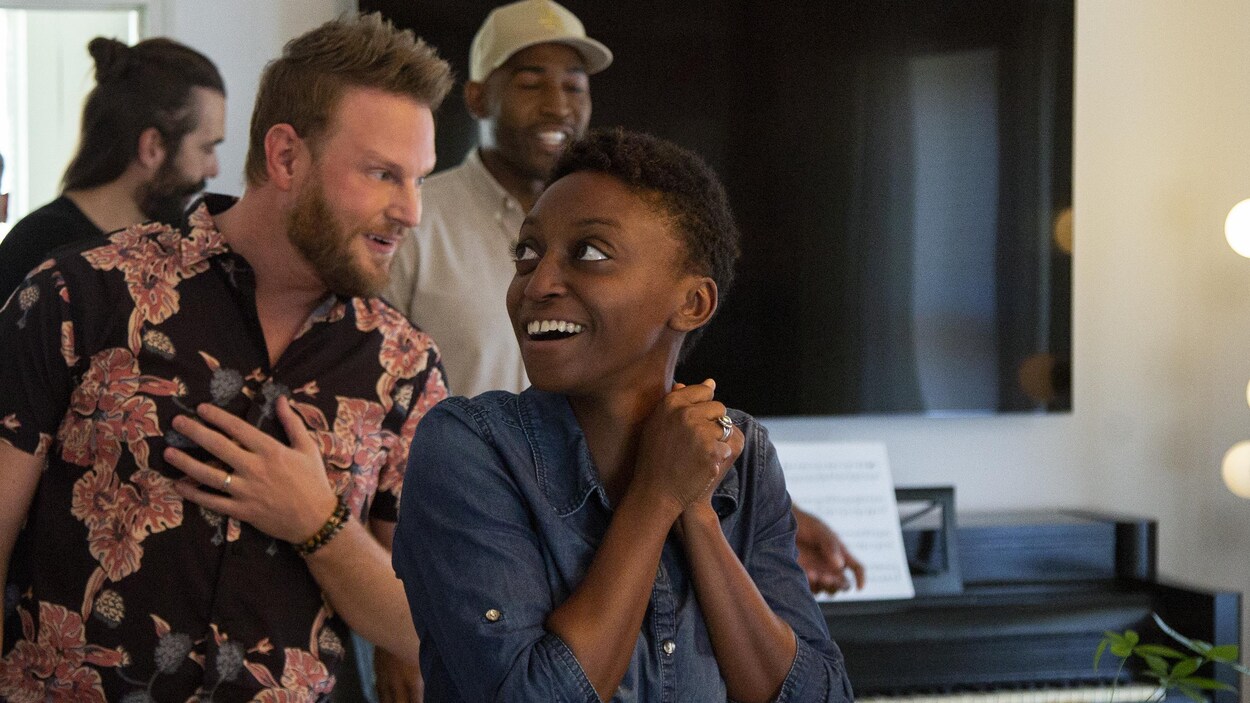 Une jeune femme, tout sourire, regarde le nouveau décor que lui a offert le designer Bobby Berk.