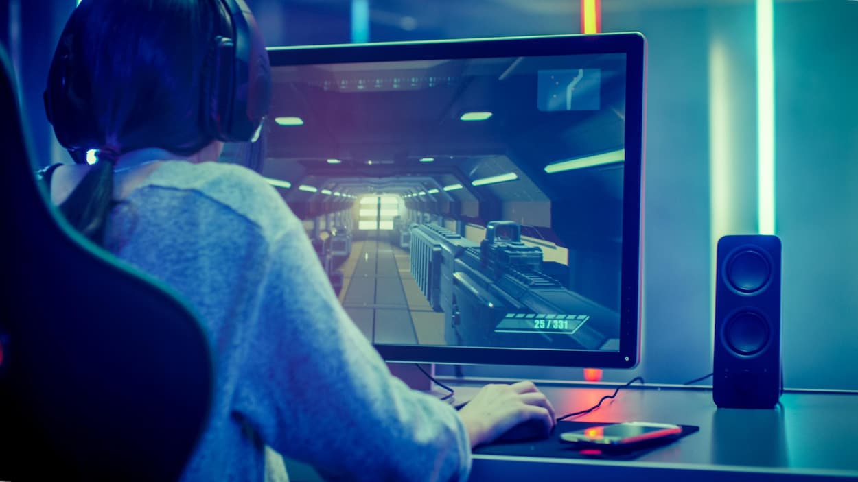 Une femme joue à un jeu vidéo sur un ordinateur.