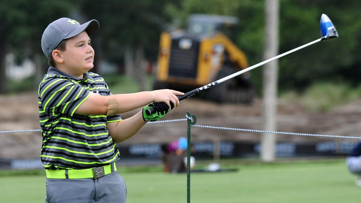 Un jeune golfeur effectue un coup de départ. Un jeune golfeur effectue un coup de départ.