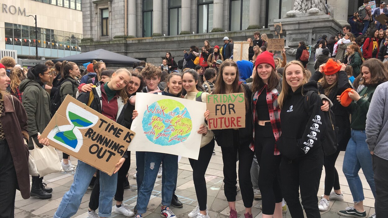 Des jeunes posent avec des pancartes lors d'une manifestation pour le climat à Vancouver.