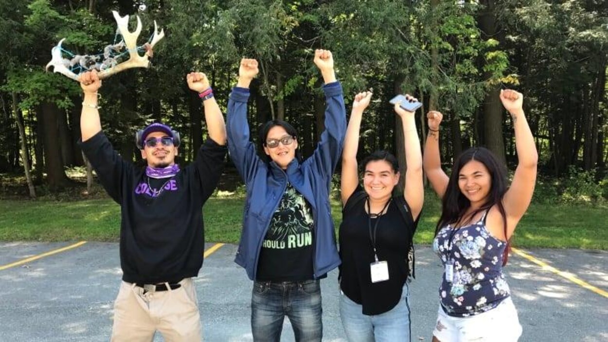 Les quatres jeunes les poings en l'air.