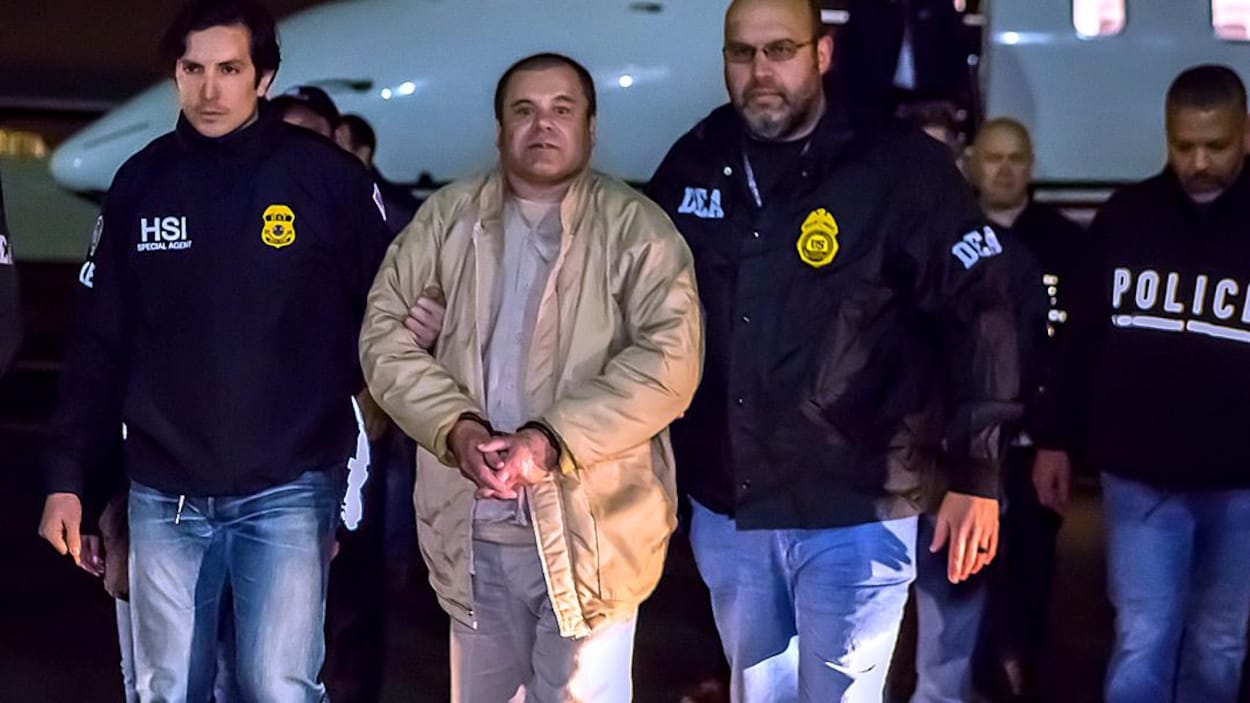 Plusieurs agents fédéraux escortent Guzman, menottes aux poings, après son arrivée du Mexique en avion.