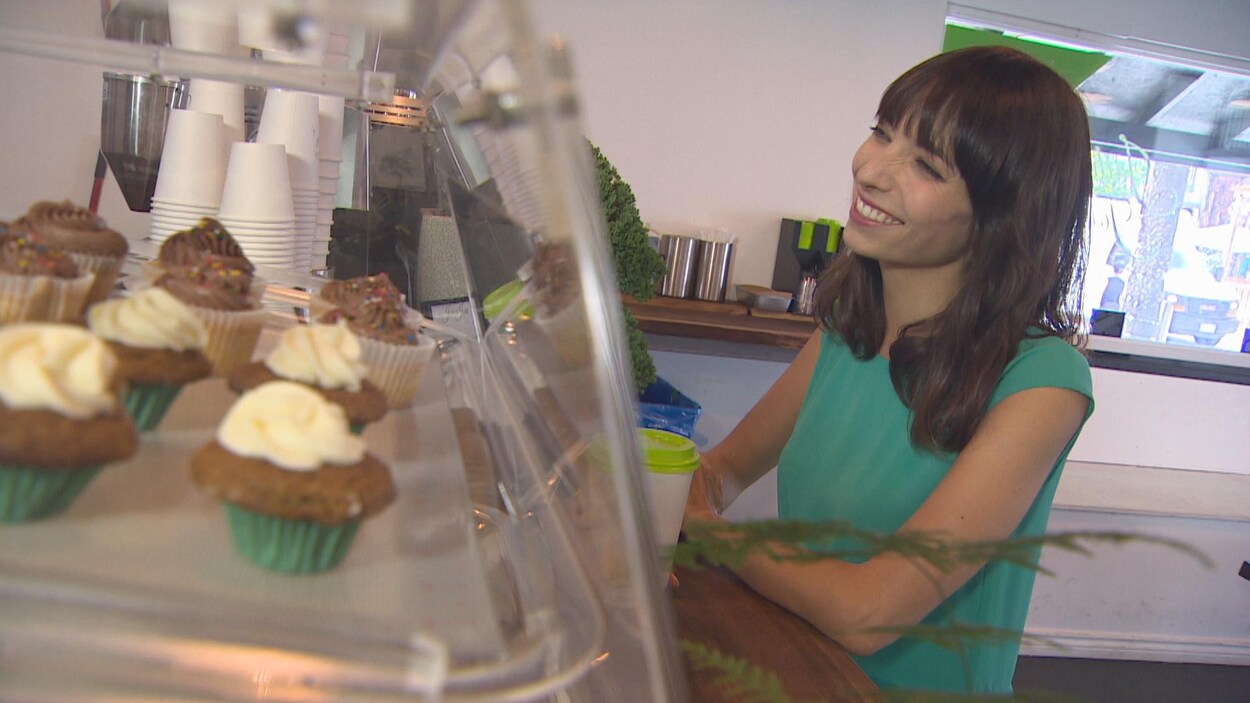 Jodie Emery devant une vitrine de cupcakes.
