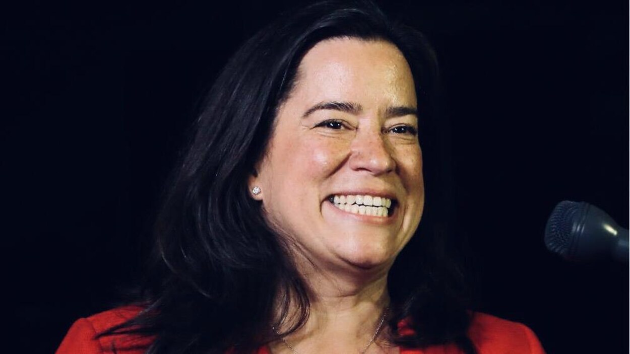 Une femme dans la quarantaine posant de face est tout sourire.