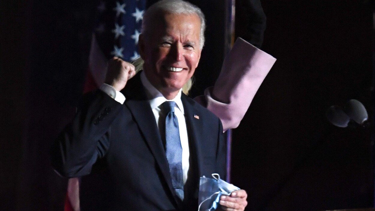 Joe Biden, souriant, le poing serré de manière victorieuse.