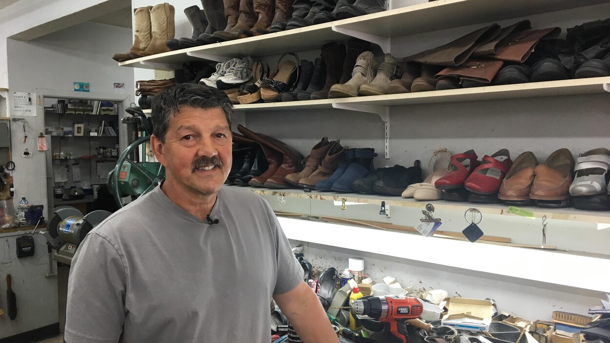 Joe LeBlanc devant un étalage de souliers.