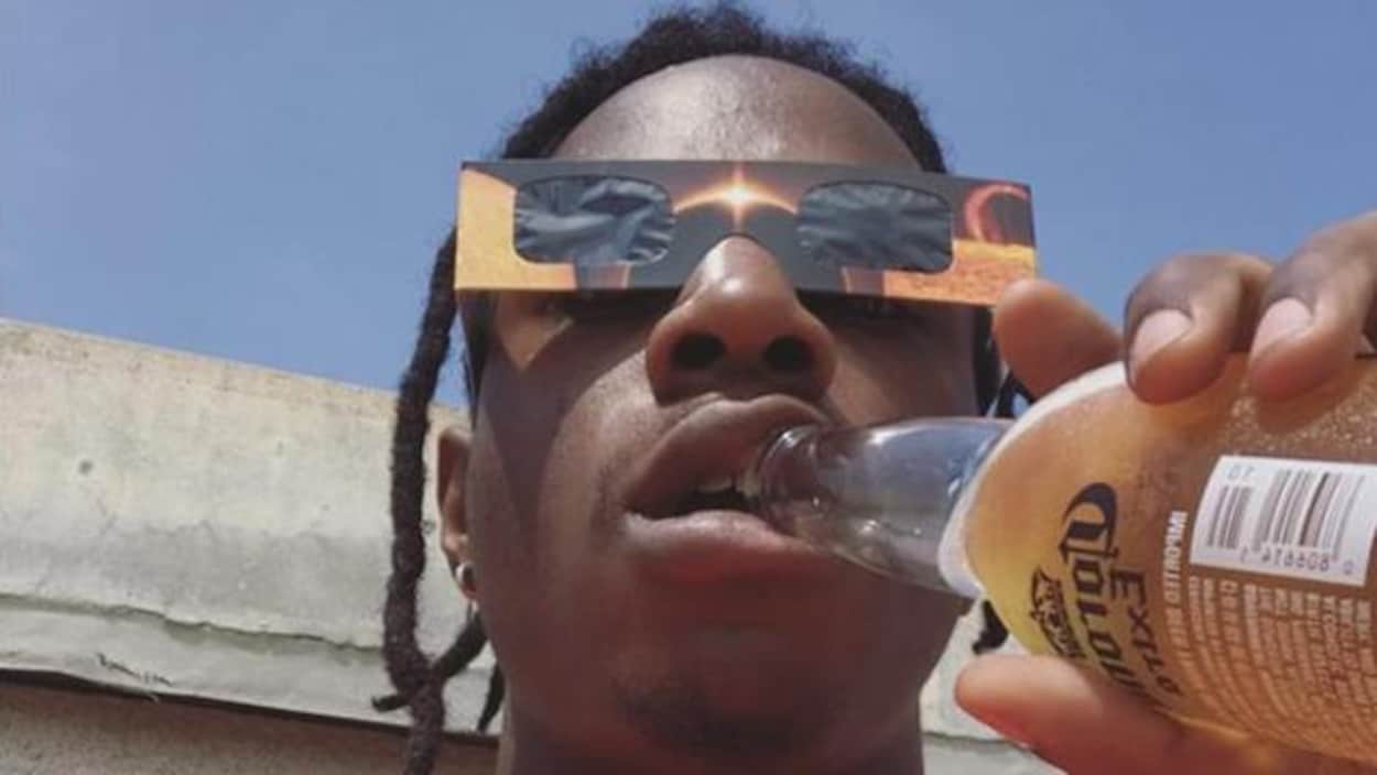 Le rappeur Joey Bada$$ portant des lunettes protectrices pendant l'éclipse du 21 août.