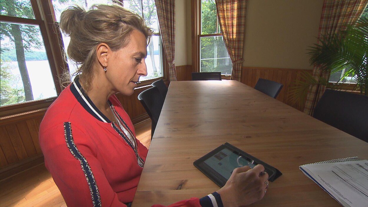 Johanne Lavoie regarde une tablette.