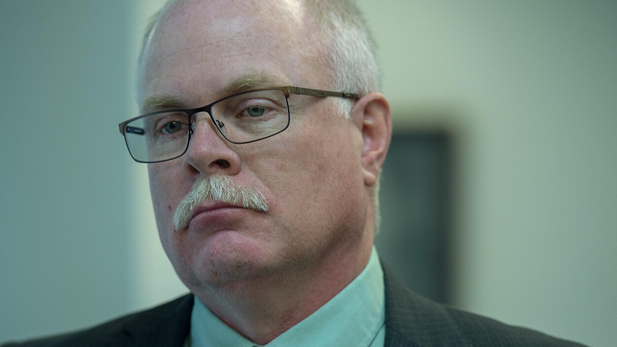 Un homme portant lunettes et moustache.