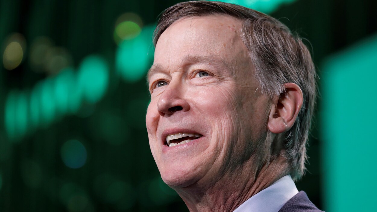 John Hickenlooper, photographié de trois quarts, souriant et regardant devant lui
